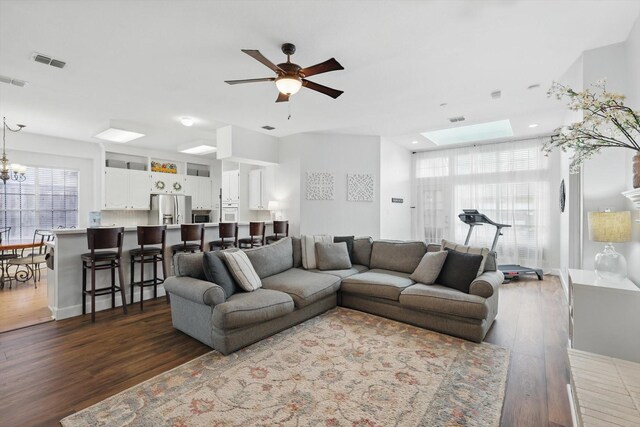 4516 Ridgepointe Dr, The Colony, TX 75056 - living room featuring dark wood-type flooring, a chandelier, a ceiling fan, a skylight, and recessed lighting