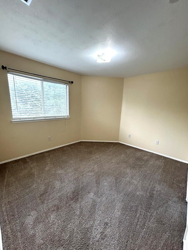 1505 Yellowbird Ct, Desoto, TX 75115 - spare room featuring dark carpet and a textured ceiling