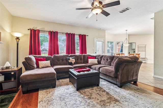1418 Harmony Ln, Carrollton, TX 75006 - living area featuring healthy amount of natural light, a ceiling fan, wood finished floors, and baseboards