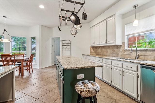 1418 Harmony Ln, Carrollton, TX 75006 - kitchen with stainless steel dishwasher, a sink, healthy amount of natural light, tasteful backsplash, and recessed lighting