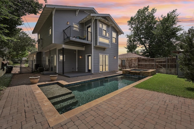 3804 Mattison Ave, Fort Worth, TX 76107 - back of house at dusk with a balcony, a patio, a fenced backyard, and a pool with connected hot tub