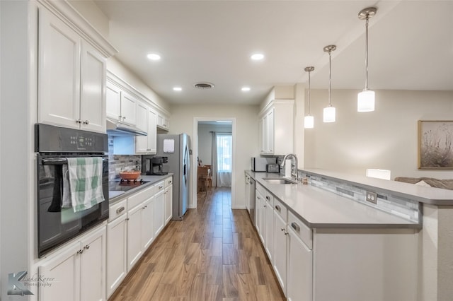 3126 Salinas Dr, Abilene, TX 79605 - kitchen with stainless steel appliances, a sink, backsplash, light wood finished floors, and white cabinetry