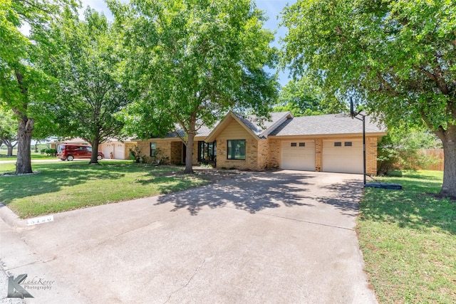 3126 Salinas Dr, Abilene, TX 79605 - view of front of home with brick siding, a garage, concrete driveway, a front lawn, and roof with shingles