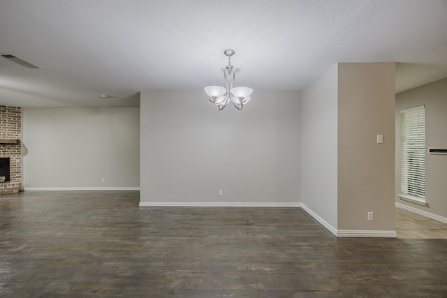 1624 Summer Place Cir, Irving, TX 75062 - empty room featuring a chandelier, a brick fireplace, baseboards, and wood finished floors