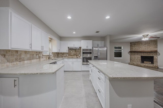 1624 Summer Place Cir, Irving, TX 75062 - kitchen featuring appliances with stainless steel finishes, a sink, a ceiling fan, decorative backsplash, and light stone countertops
