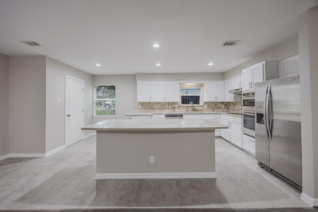 1624 Summer Place Cir, Irving, TX 75062 - kitchen with stainless steel appliances, a center island, tasteful backsplash, white cabinets, and recessed lighting