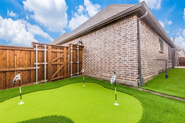 8532 Melrose, The Colony, TX 75056 - view of home's exterior featuring brick siding, a gate, a putting area, and a shingled roof