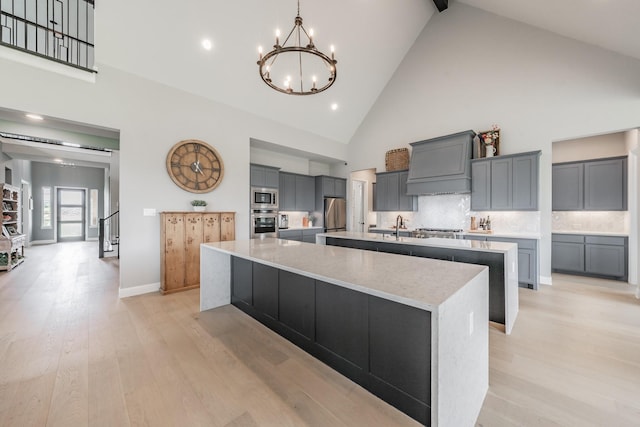 562 Broadleaf Way, Haslet, TX 76052 - kitchen featuring a large island, appliances with stainless steel finishes, high vaulted ceiling, a chandelier, and custom exhaust hood