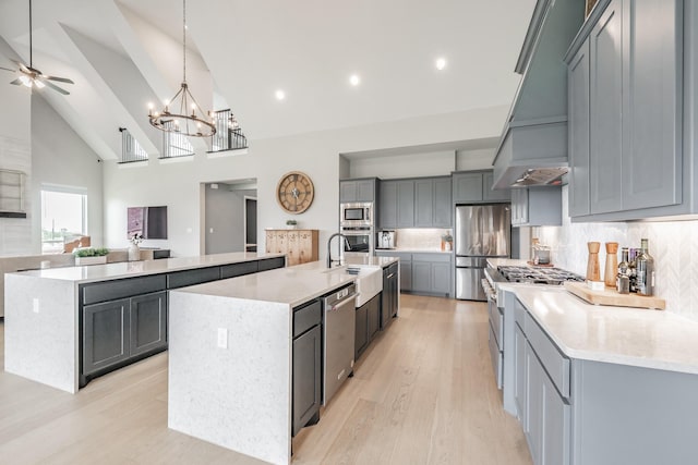 562 Broadleaf Way, Haslet, TX 76052 - kitchen with a large island, appliances with stainless steel finishes, a sink, light wood-type flooring, and high vaulted ceiling