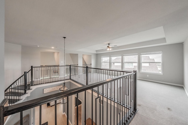 562 Broadleaf Way, Haslet, TX 76052 - hallway with a tray ceiling, carpet, baseboards, and an upstairs landing