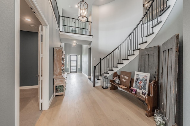562 Broadleaf Way, Haslet, TX 76052 - foyer entrance with baseboards, wood finished floors, stairway, a towering ceiling, and a chandelier