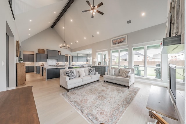 562 Broadleaf Way, Haslet, TX 76052 - living area with high vaulted ceiling, light wood finished floors, beam ceiling, a ceiling fan, and a chandelier