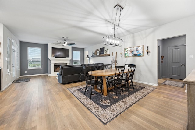 168 Ridgetop Trl, Rhome, TX 76078 - dining room with a fireplace, light wood-type flooring, ceiling fan, and baseboards