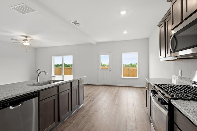 426 Gib Woodall Dr, Venus, TX 76084 - kitchen with stainless steel appliances, a sink, dark brown cabinets, light wood-type flooring, and recessed lighting
