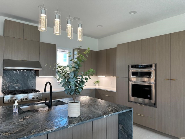 4715 Glavica Dr, Irving, TX 75062 - kitchen with under cabinet range hood, double oven, a sink, dark stone countertops, and tasteful backsplash