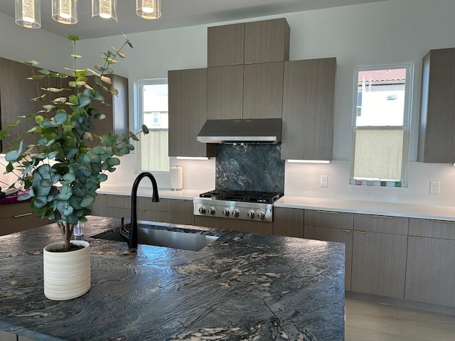 4715 Glavica Dr, Irving, TX 75062 - kitchen with under cabinet range hood, a sink, modern cabinets, and stainless steel gas stovetop