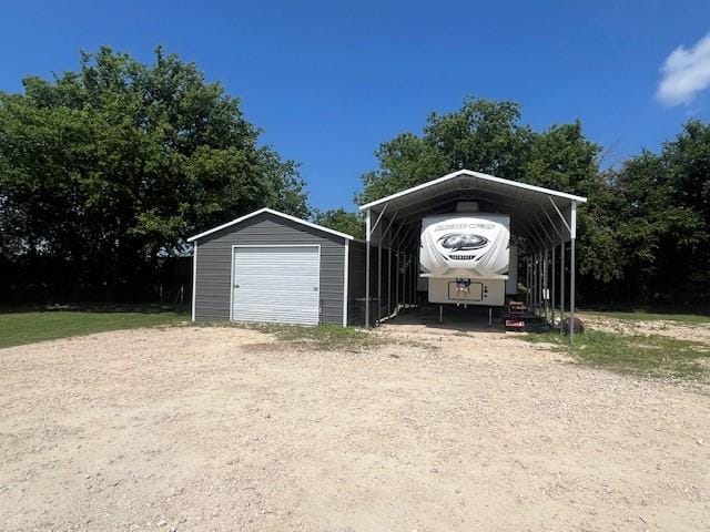 214 Hemphill St, Hico, TX 76457 - view of parking featuring a carport, a garage, and dirt driveway