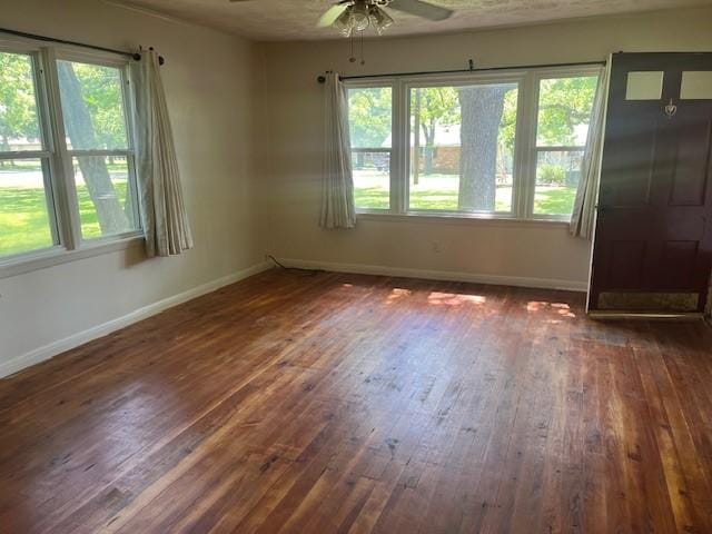 214 Hemphill St, Hico, TX 76457 - unfurnished room featuring a ceiling fan, dark wood finished floors, and baseboards