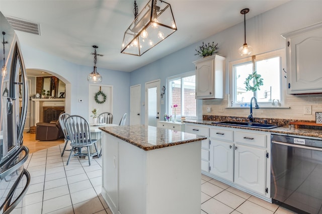3820 Blossom Dr, Sachse, TX 75048 - kitchen featuring dishwasher, stainless steel refrigerator with ice dispenser, a sink, a center island, and arched walkways