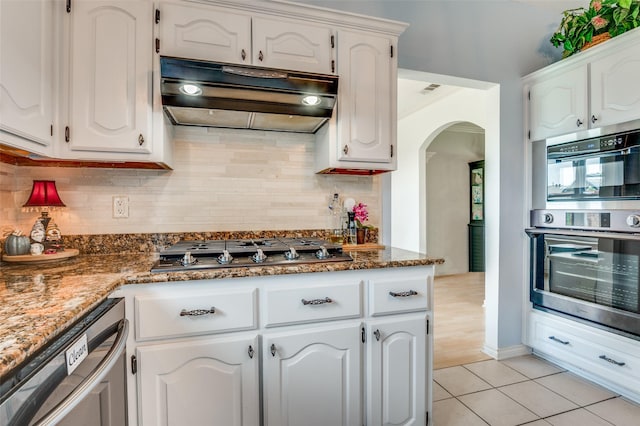 3820 Blossom Dr, Sachse, TX 75048 - kitchen with under cabinet range hood, appliances with stainless steel finishes, arched walkways, and backsplash