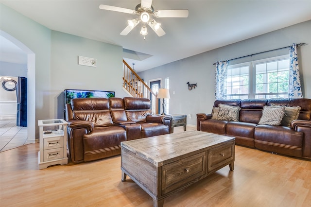 3820 Blossom Dr, Sachse, TX 75048 - living area with arched walkways, stairway, ceiling fan, light wood-style flooring, and baseboards