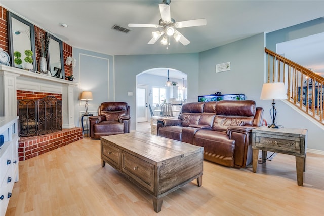 3820 Blossom Dr, Sachse, TX 75048 - living area with arched walkways, a ceiling fan, light wood-style floors, and a fireplace