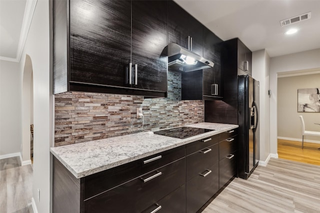 9705 Ash Creek Dr, Dallas, TX 75228 - kitchen featuring extractor fan, black appliances, light wood finished floors, arched walkways, and backsplash
