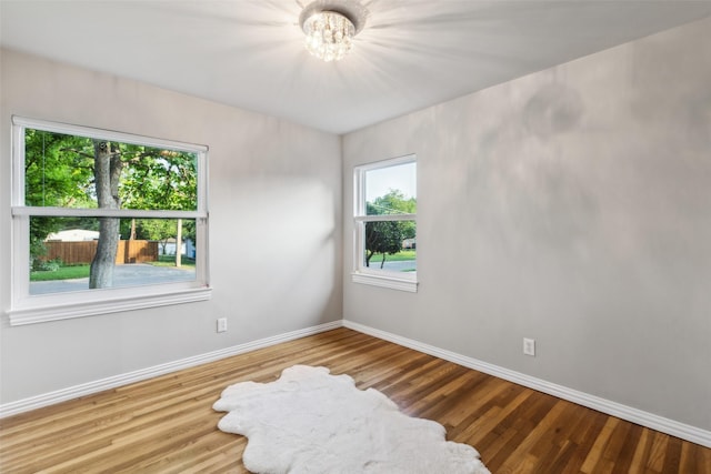 9705 Ash Creek Dr, Dallas, TX 75228 - empty room featuring baseboards, wood finished floors, and a chandelier