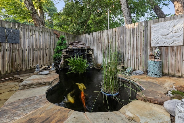 9705 Ash Creek Dr, Dallas, TX 75228 - fenced backyard with a garden pond and a patio