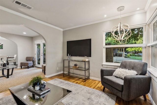 9705 Ash Creek Dr, Dallas, TX 75228 - living room featuring arched walkways, plenty of natural light, wood finished floors, a chandelier, and crown molding