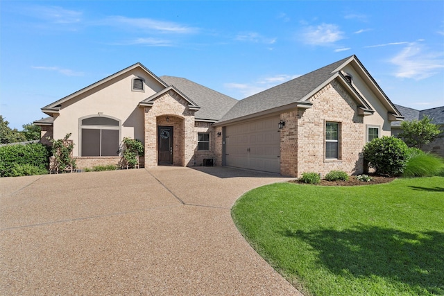 41 N Shore Cir, Waco, TX 76708 - view of front of home featuring brick siding, driveway, a front lawn, an attached garage, and roof with shingles