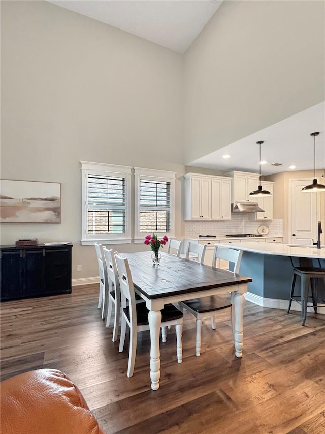 2219 Wellington Ln, Corinth, TX 76210 - dining space featuring wood finished floors, a high ceiling, and baseboards