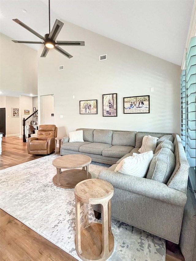 2219 Wellington Ln, Corinth, TX 76210 - living area featuring wood finished floors, a ceiling fan, high vaulted ceiling, stairs, and baseboards