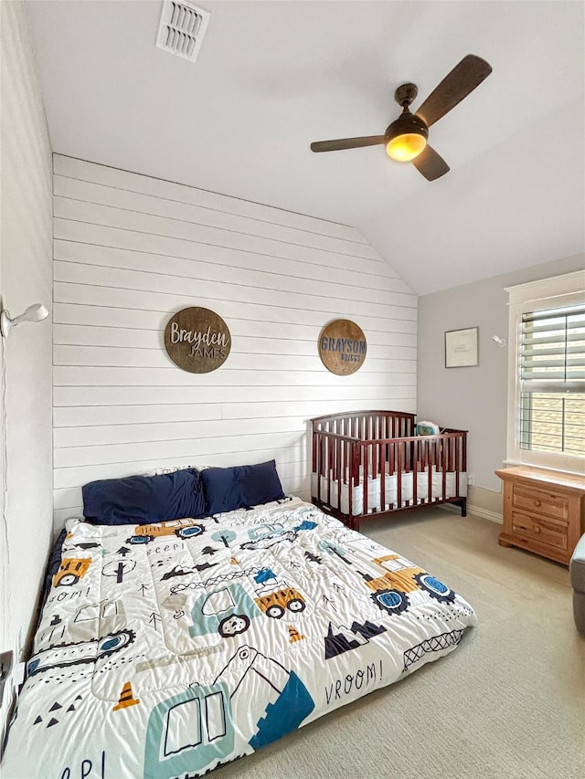 2219 Wellington Ln, Corinth, TX 76210 - carpeted bedroom with vaulted ceiling, wooden walls, a ceiling fan, and baseboards