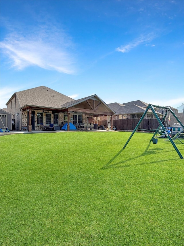 2219 Wellington Ln, Corinth, TX 76210 - back of house featuring a playground, a patio area, and a shingled roof