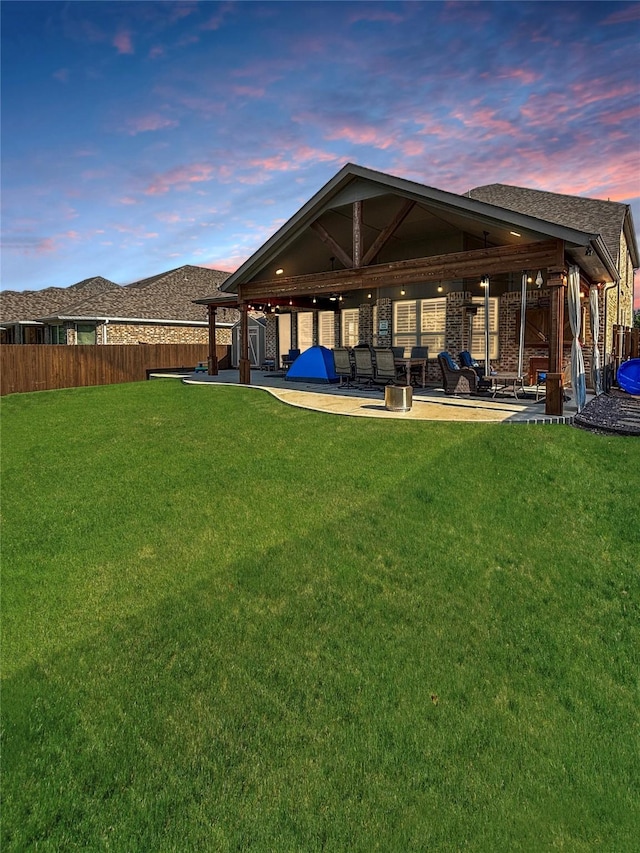 2219 Wellington Ln, Corinth, TX 76210 - back of property at dusk with a patio