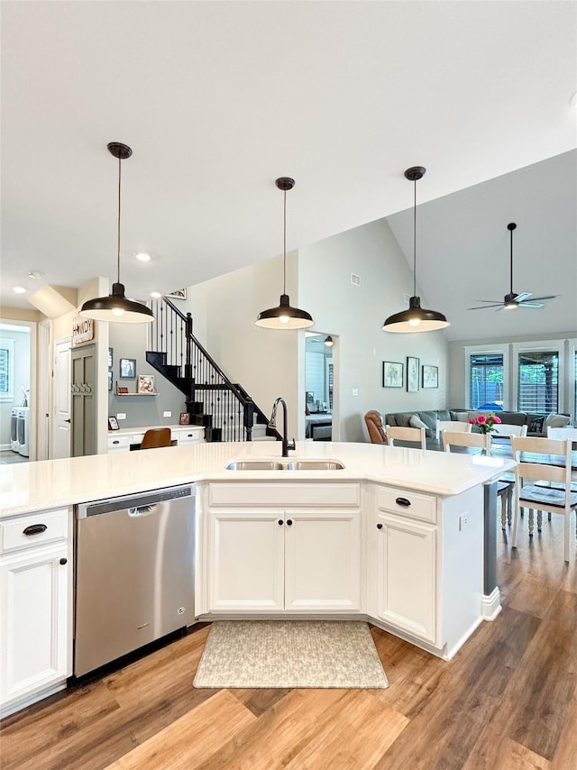 2219 Wellington Ln, Corinth, TX 76210 - kitchen with stainless steel dishwasher, a sink, open floor plan, a ceiling fan, and light countertops