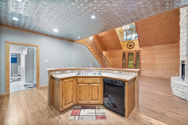 108 Fcr 868, Teague, TX 75860 - kitchen with black dishwasher, tile countertops, a sink, open floor plan, and wooden walls