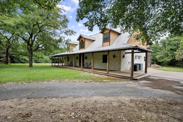 108 Fcr 868, Teague, TX 75860 - view of side of home featuring covered porch, a yard, metal roof, central AC unit, and stone siding