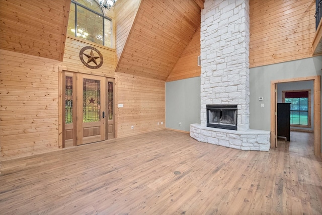 108 Fcr 868, Teague, TX 75860 - unfurnished living room featuring high vaulted ceiling, wood finished floors, wooden walls, a stone fireplace, and wooden ceiling