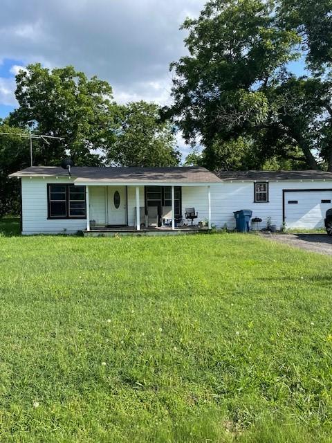 504 E Polk Ave, Whitney, TX 76692 - ranch-style house featuring a front lawn, an attached garage, and driveway