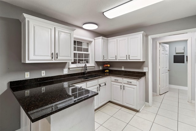 110 Harmon Cir, Blue Ridge, TX 75424 - kitchen with a sink, white cabinets, a peninsula, light tile patterned floors, and dark stone countertops