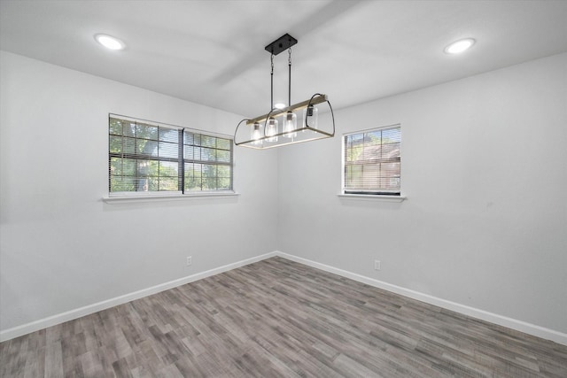 1312 E Collin, Corsicana, TX 75110 - unfurnished room with a chandelier, wood finished floors, baseboards, and recessed lighting
