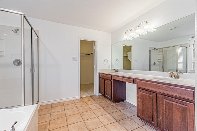 6547 Portside Ridge Ln, Dallas, TX 75249 - full bathroom featuring a stall shower, double vanity, tile patterned flooring, a spacious closet, and tiled bath