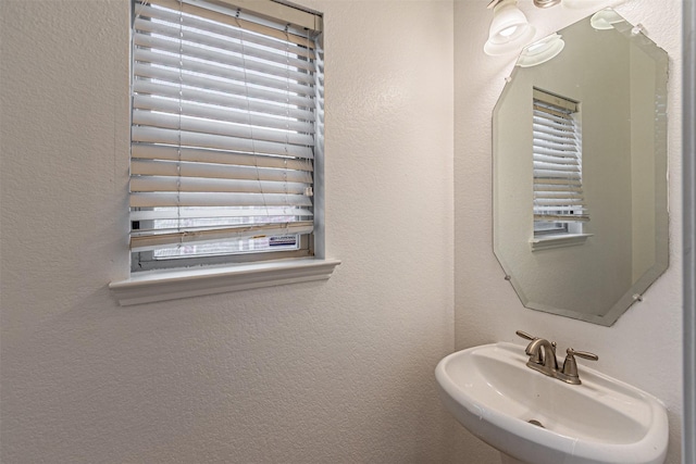 6547 Portside Ridge Ln, Dallas, TX 75249 - bathroom featuring a textured wall, a sink, and plenty of natural light