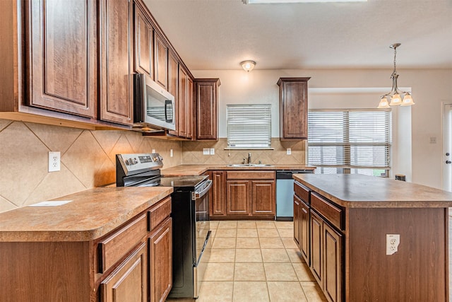 6547 Portside Ridge Ln, Dallas, TX 75249 - kitchen with stainless steel appliances, decorative backsplash, light tile patterned floors, pendant lighting, and a center island