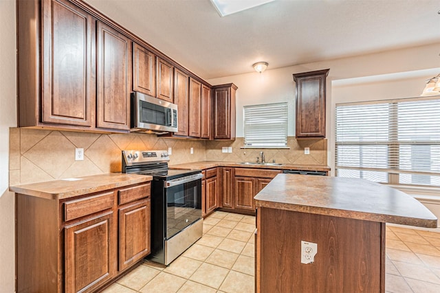 6547 Portside Ridge Ln, Dallas, TX 75249 - kitchen with appliances with stainless steel finishes, a sink, light tile patterned floors, backsplash, and a kitchen island