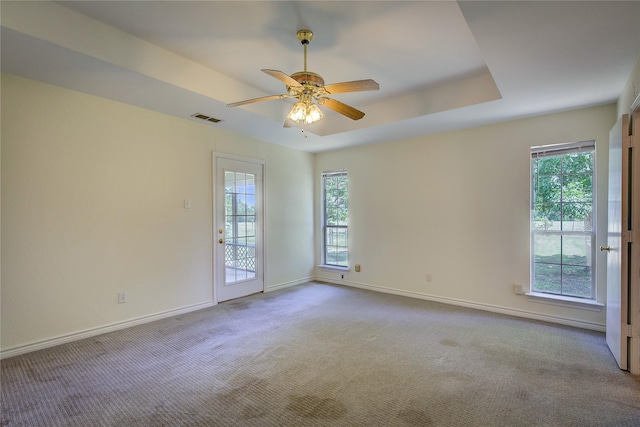 5701 Fm 2101, Quinlan, TX 75474 - carpeted empty room with plenty of natural light, baseboards, a ceiling fan, and a tray ceiling