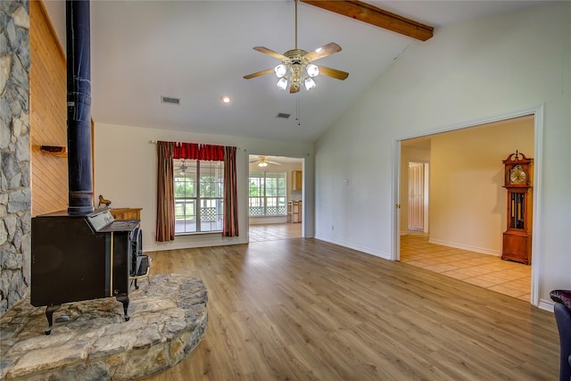 5701 Fm 2101, Quinlan, TX 75474 - living room featuring a wood stove, a ceiling fan, wood finished floors, beam ceiling, and high vaulted ceiling