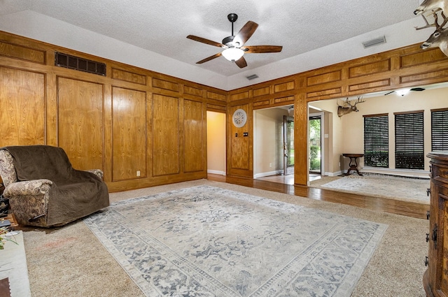 3313 Conlin Dr, Rowlett, TX 75088 - sitting room featuring a ceiling fan, a textured ceiling, and wood walls